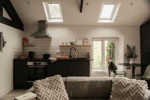 ein Wohnzimmer mit Couch und Küche in der Unterkunft The Bothy - A secluded and romantic rural retreat in Llanddyfnan