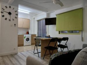 a living room with a table and a clock on the wall at Piso recien reformado in Zaragoza