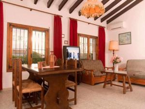 a living room with a table and a living room with red curtains at Holiday Home Sibila in Jávea