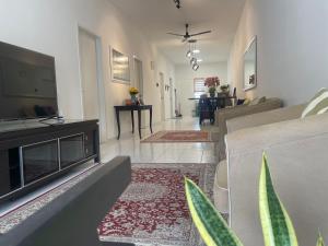 a living room with a television and a living room with a couch at Inap Kasturi D'Gambang in Gambang