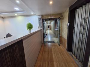 corridoio di un ufficio con bancone della reception e corridoio di Hotel Paradise a Jamnagar