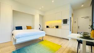 a bedroom with a bed and a table and a kitchen at Studio Fischer à la Pétrusse 002 in Luxembourg