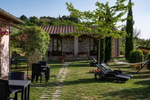 蒙特普齐亚诺拉皮耶薇娜酒店的一个带桌椅的庭院和一座房子