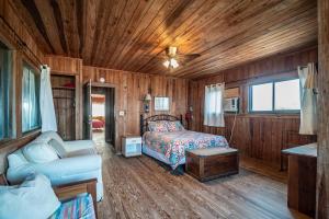 ein Schlafzimmer mit einem Bett und einer Couch in einem Zimmer in der Unterkunft Ocean Breezes Historic Home with Creek Dock in Pawleys Island