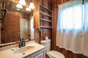 ein Badezimmer mit Toilette, Waschbecken und Spiegel in der Unterkunft Ocean Breezes Historic Home with Creek Dock in Pawleys Island