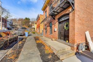 a brick building with a sidewalk next to a street at Walk to Waterfront Chic Hudson Valley Garden Apt in Kingston