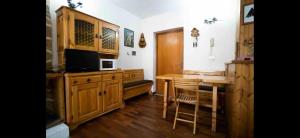 a kitchen with wooden cabinets and a table with a microwave at Pescocostanzo s Home park&garden in Pescocostanzo