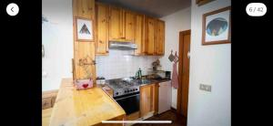 a kitchen with wooden cabinets and a stove top oven at Pescocostanzo s Home park&garden in Pescocostanzo