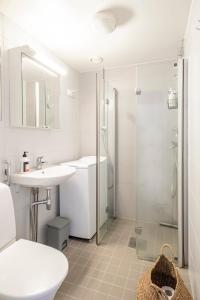 une salle de bain avec un lavabo, une douche et des toilettes dans l'établissement Central and Hip w King Bed, 50m tram and bus, Netflix, à Helsinki