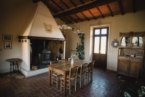Un comedor con mesa y chimenea. en Agriturismo Il Rigo, en San Quirico dʼOrcia