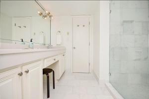 a white bathroom with a sink and a shower at Tranquil Getaway 2BR Ocean Views Onsite Amenities in Pawleys Island