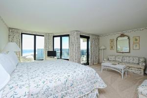 une chambre avec un lit, un canapé et des fenêtres dans l'établissement Coastal Oasis Inviting 3BR Condo with Resort Pool, à Pawleys Island