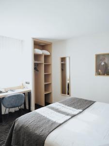 a bedroom with a bed and a desk and a table at Logis Le Clos Deauville Saint Gatien in Saint-Gâtien-des-Bois