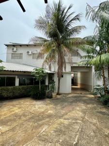 a palm tree in front of a white building at Hotel Lunna in Porto Nacional +21 photos