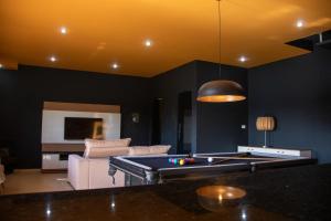 uma sala de estar com uma mesa de sinuca e um sofá em Pousada Recanto de Igaratá em Igaratá