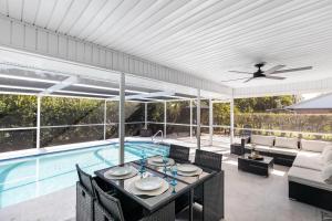 a patio with a table and chairs and a pool at Naples Gem Near Beach Heated Pool & BBQ in Naples