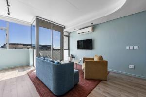 a living room with a blue couch and a tv at Quarter 411 in Cape Town
