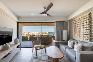a living room with a couch and a tv at Punto Nima, Spectacular Pool with Ocean View in San José del Cabo