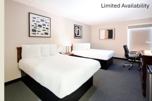 a hotel room with two beds and a desk at The View Inn & Suites Bethlehem / Allentown / Lehigh Airport in Bethlehem