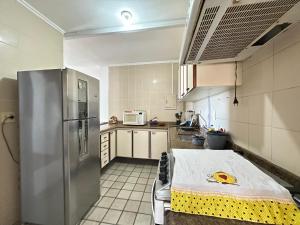 a kitchen with a stainless steel refrigerator in it at Ap 3 quartos praia grande vista pro mar área nobre in Ubatuba