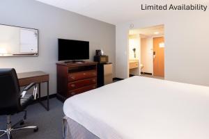 a hotel room with a bed and a desk and a television at The View Inn & Suites Bethlehem / Allentown / Lehigh Airport in Bethlehem