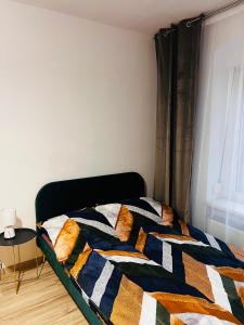 uma cama com uma colcha colorida num quarto em Apartament na Grodowej koło Rynku em Gliwice