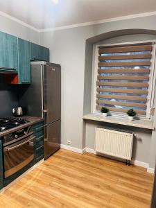 uma cozinha com um frigorífico de aço inoxidável e uma janela em Apartament na Grodowej koło Rynku em Gliwice
