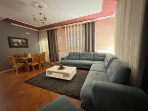 Una sala de estar con un sofá azul y una mesa. en THE DOMI Apartments, en Durrës