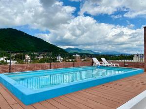 a swimming pool on the roof of a building with mountains at Augusto Apart 3 in Salta