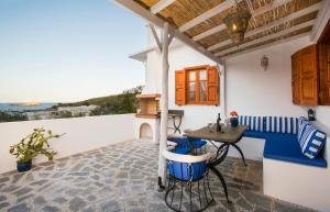 Lindos Seaside Villa في ليندوس: فناء مع طاولة وكراسي وإطلالة على المحيط