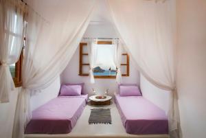 two beds in a room with curtains and a window at Lindos Seaside Villa in Lindos