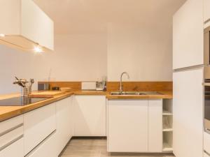 a white kitchen with white cabinets and a sink at Appartement spacieux 8 pers, balcon, centre station - FR-1-346-400 in Arc 1800