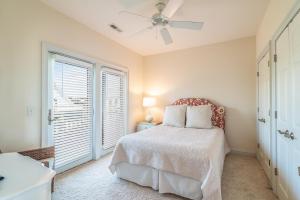 sypialnia z łóżkiem z wentylatorem sufitowym i oknem w obiekcie Luxurious Beachfront Escape with Spectacular Views w mieście Pawleys Island