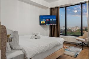 a hotel room with a bed and a flat screen tv at Crown Penthouse - Luxurious, Spa & Vista , by Uni88 ApartHotel in Bucharest