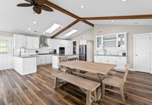 a kitchen with white cabinets and a wooden table at Beachside Getaway private Lake Michigan Beach Frontage in Spring Lake