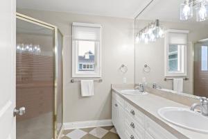 a white bathroom with two sinks and a shower at Beachside Getaway private Lake Michigan Beach Frontage in Spring Lake +32 photos