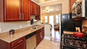a kitchen with wooden cabinets and a black refrigerator at Chic 1 BR Units Near Dilworth in Charlotte