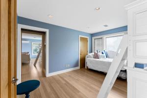 a bedroom with blue walls and a bed at Dreamview- Private Lake frontage in Spring Lake