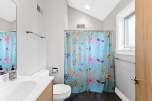 a bathroom with a shower curtain with flowers on it at Dreamview- Private Lake frontage in Spring Lake +42 photos