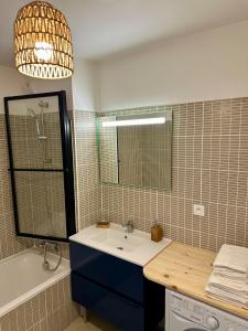 a bathroom with a sink and a mirror and a tub at Très bel appartement - 2 chambres in Montpellier