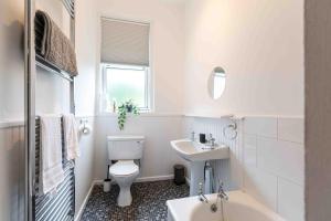a white bathroom with a toilet and a sink at Spacious 3 bed home in Marchmont in Edinburgh +11 photos