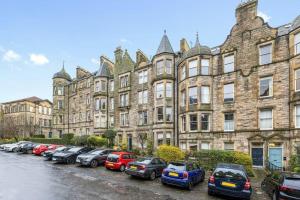 a row of cars parked in front of a large building at Spacious 3 bed home in Marchmont in Edinburgh