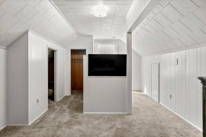 an empty room with a flat screen tv on a white wall at Cozy 4 Bedroom-Outdoor furniture- 2 bathrooms in Dearborn Heights