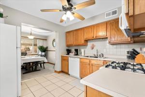 a kitchen with wooden cabinets and a ceiling fan at Near Greenfield Village-Downtown Dearborn-Oakwood in Dearborn