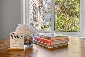 a group of books on a table with a window at Cozy 3 Bedroom Near Airport And Downtown Detroit in Dearborn Heights