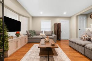 a living room with a couch and a tv at Newly Renovated in Historic Neighborhood Near DTW in Dearborn