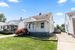 a white house with a porch at Cozy Home Fenced Yard Pets Welcome Great Location in Lincoln Park