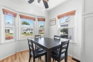 a dining room with a table and chairs and windows at Cozy Home Fenced Yard Pets Welcome Great Location in Lincoln Park