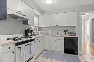 a kitchen with white cabinets and a stove top oven at 3 Bedroom Fenced Backyard Pets Welcome Sleeps 6 in Lincoln Park +6 photos