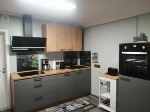 バート・ラウターベルクにあるDernedde Ferienwohnungの白いキャビネットと黒の電化製品が備わるキッチン